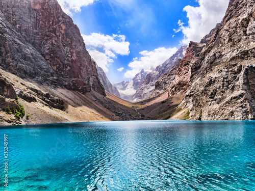 Fototapeta Naklejka Na Ścianę i Meble -  Big Alo mountain lake with turquoise water in sunshine on rocky mountain background. The Fann Mountains, Tajikistan, Central Asia