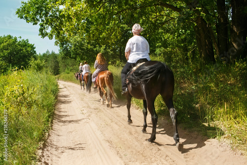 A group of tourists on horseback with an instructor for a walk. photo