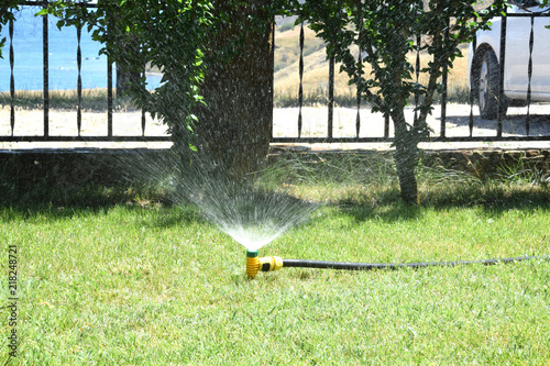 искусственная оросительная система поливает растения в жаркий летний день