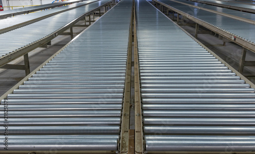 Low, converging perspective of industrial steel roller conveyors.