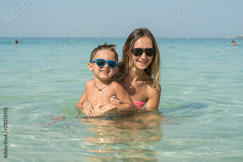 Happy smiling family having fun on tropical white beach (Maldives islands). Mother and cute son. Positive human emotions, feelings, joy. Spring, summer and winter holidays. © Evgenia