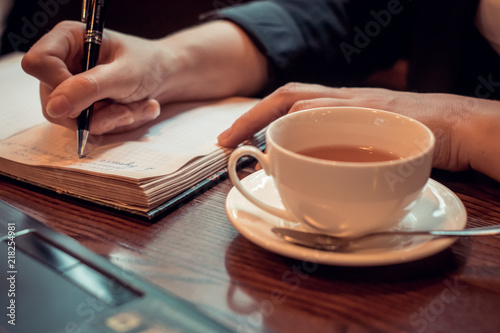 a young woman works in a coffee shop with Notepad