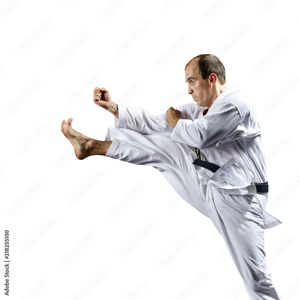 Young athlete strikes with a kick forward on a white background isolated Young athlete strikes with a kick forward on a white background isolated