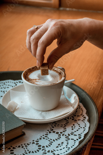woman puts sugar in coffee