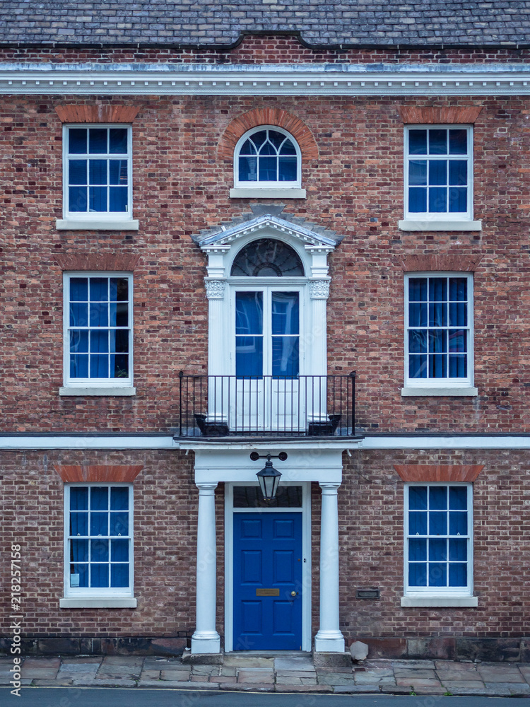 Old European brick facade with windows and colmns in a symmetrical style