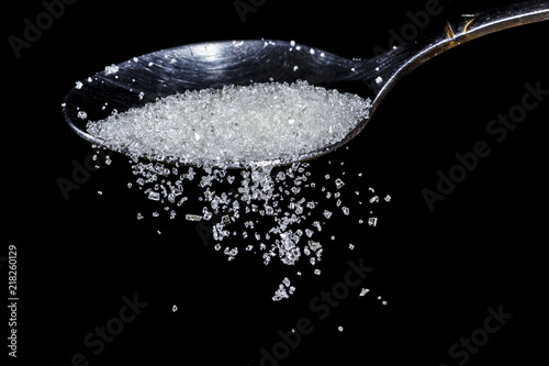 closeup of sugar falling from a teaspoon