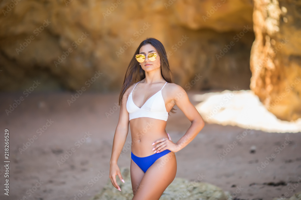 Beautiful young latin woman in sexy bikini standing at sea beach Beautiful young latin woman in sexy bikini standing at sea beach