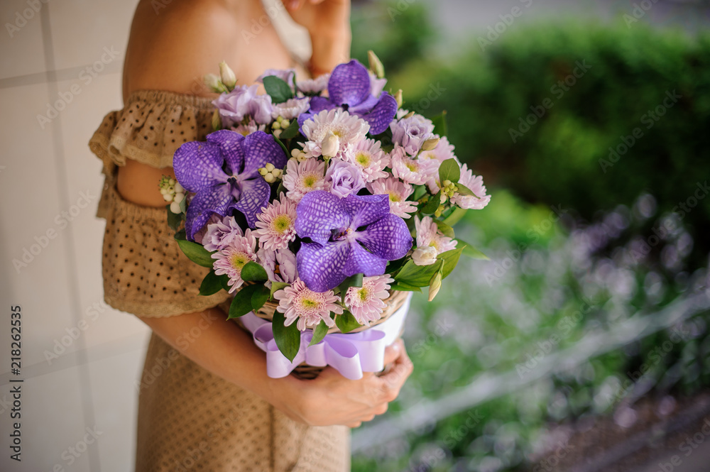 Young girl holding a basket of violet flowers