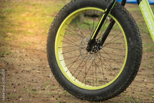 Phuket  Thailand - 10 August 2018- close up of front big wheel mountain bike on ground floor with dry pine leaves and cone