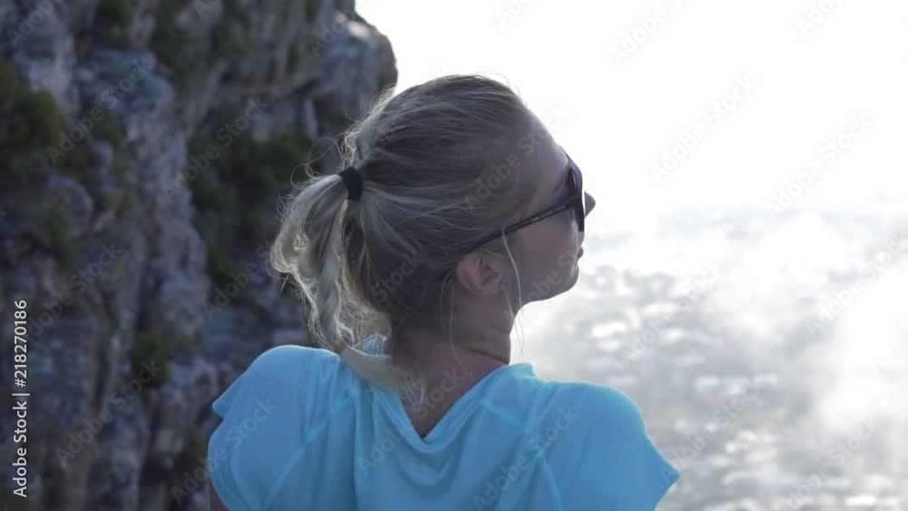 Girl turning her head in slow motion on top of Table Mountain above the clouds of Cape Town, South Africa Girl turning her head in slow motion on top of Table Mountain above the clouds of Cape Town, South Africa