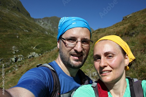 Portrait of a tired couple taking selfie in the high mountains after trekking. Fagaras Mountains, Moldoveanu Peek