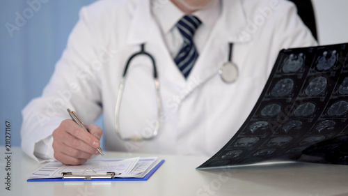Doctor prescribing medication for brain disease, examining MRI scan, insurance