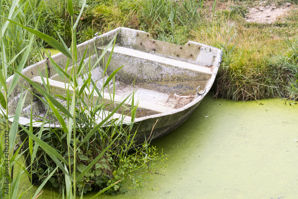 altes verlassenes Holzboot in einem Tümpel mit grünen Algen altes verlassenes Holzboot in einem Tümpel mit grünen Algen