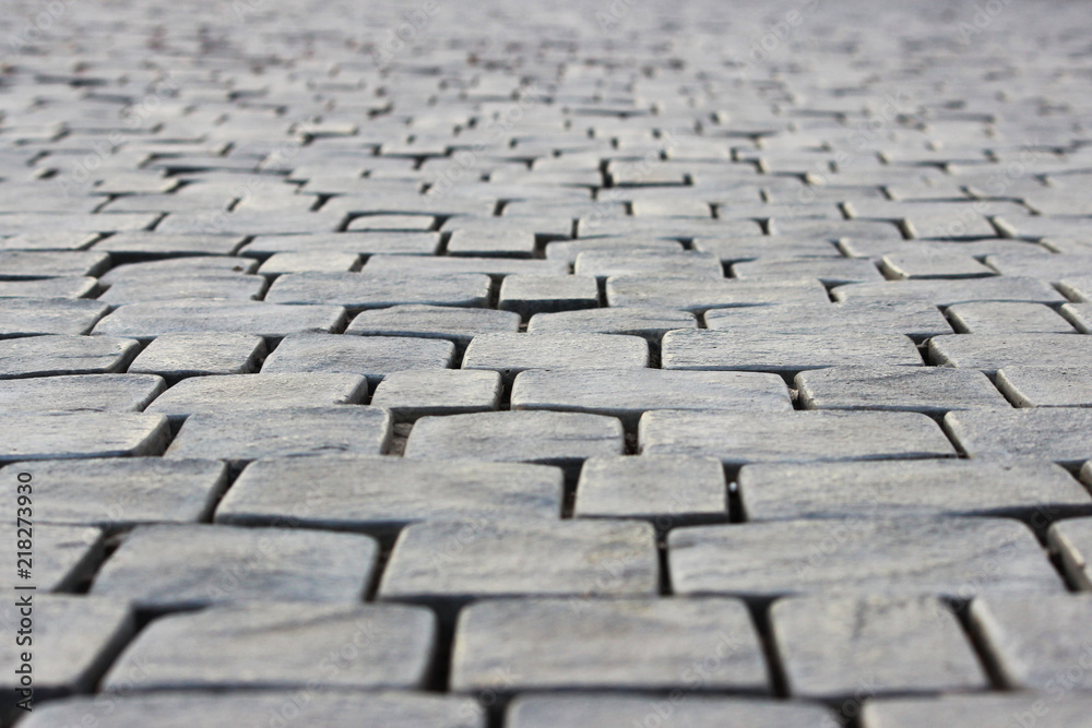Old cobblestone pavement of square stones near the Sugarloaf Mountain. Republic of Crimea. Abstract background Old cobblestone pavement of square stones near the Sugarloaf Mountain. Republic of Crimea. Abstract background