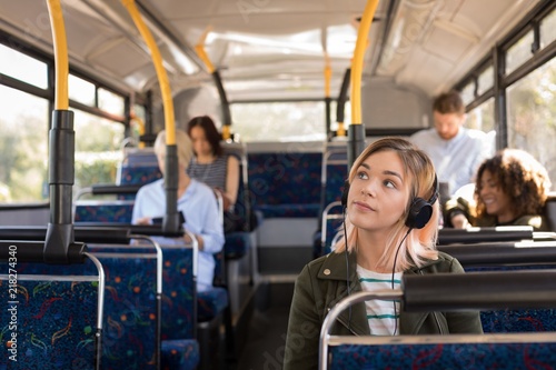 Woman listening music while travelling in modern bus