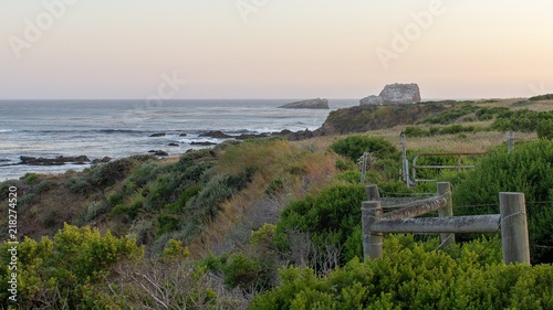 Hazy summer sunset over rock formation Big Sur California Coast