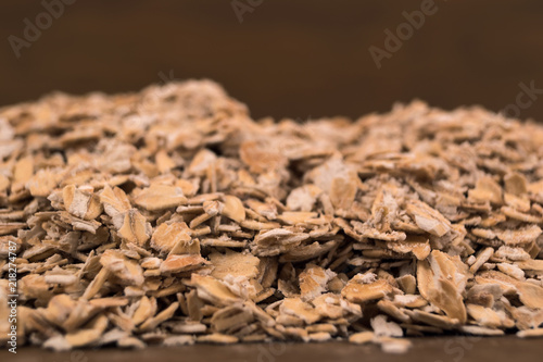 Scattered on the table oat flakes, close-up with a shallow depth of field.