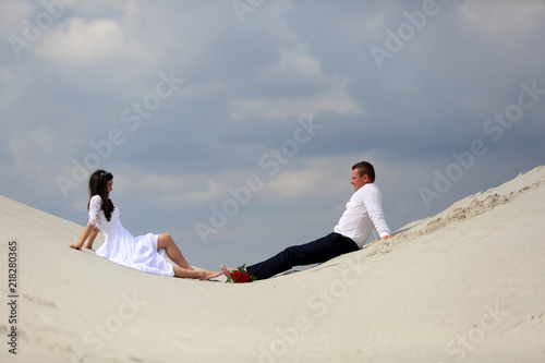 Młoda para, dziewczyna i chłopak na piaszczystej wydmie.