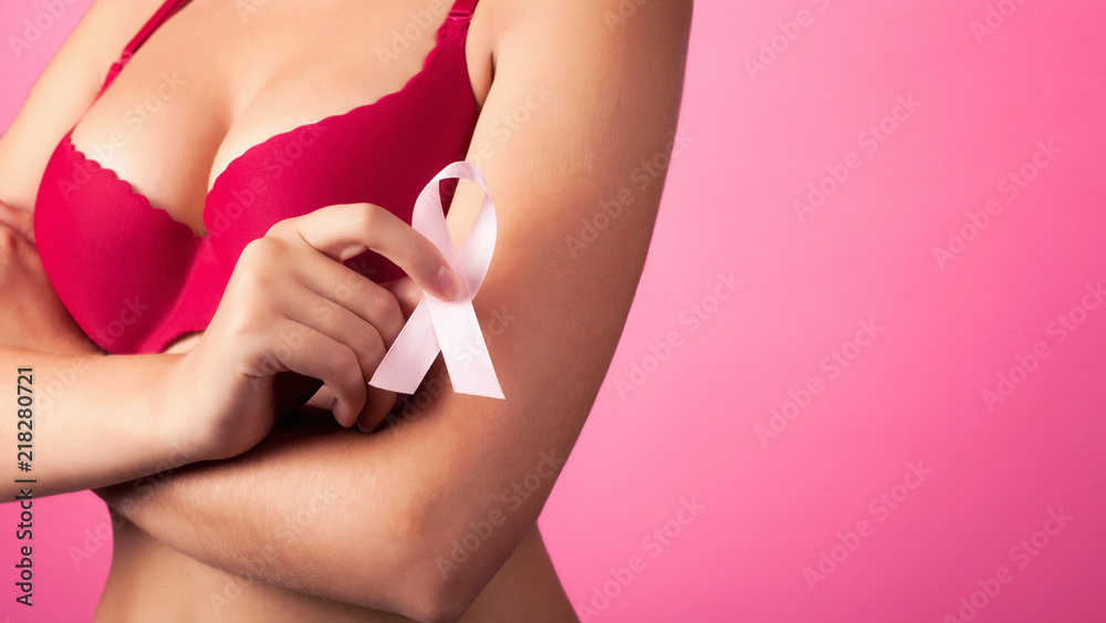 Woman with Big beautiful Breasts won Cancer. Close-up photo of a female  breast in a red bra with Pink Ribbon. Background. healthcare and medicine  concept Stock Photo