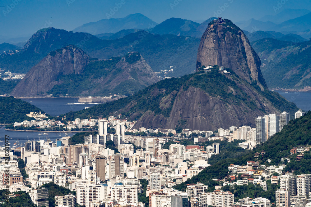 Sugarloaf mountain in Rio de Janeiro seen from a high vantage point with the city of Niteroi in the background on the other side of the bay