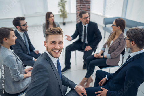 young employee sitting in a circle with business team