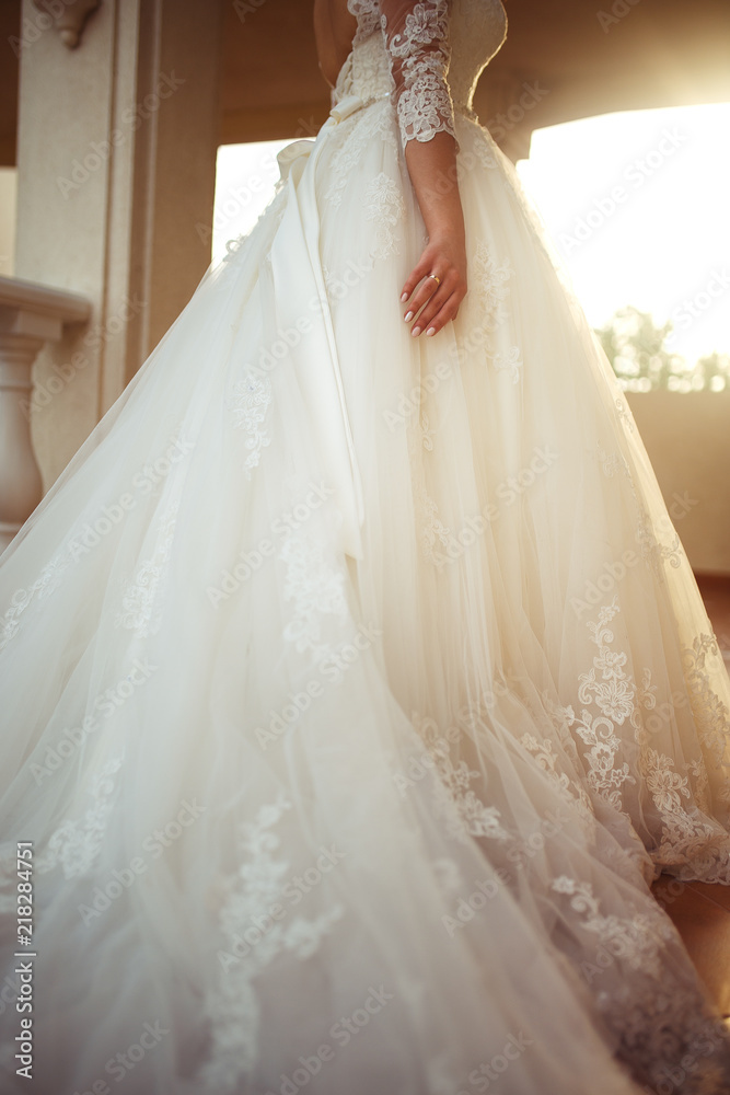 Wedding Ring on the hand of nice girl. A beautiful bride in a white wedding dress is enjoying the moment against the background of a beautiful arch in the sunset light. A fine mood,a great atmosphere. Wedding Ring on the hand of nice girl. A beautiful bride in a white wedding dress is enjoying the moment against the background of a beautiful arch in the sunset light. A fine mood,a great atmosphere.