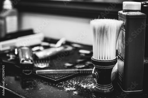 brush for shaving beard along with bowl, blurred background of hair salon for men, barber shop
