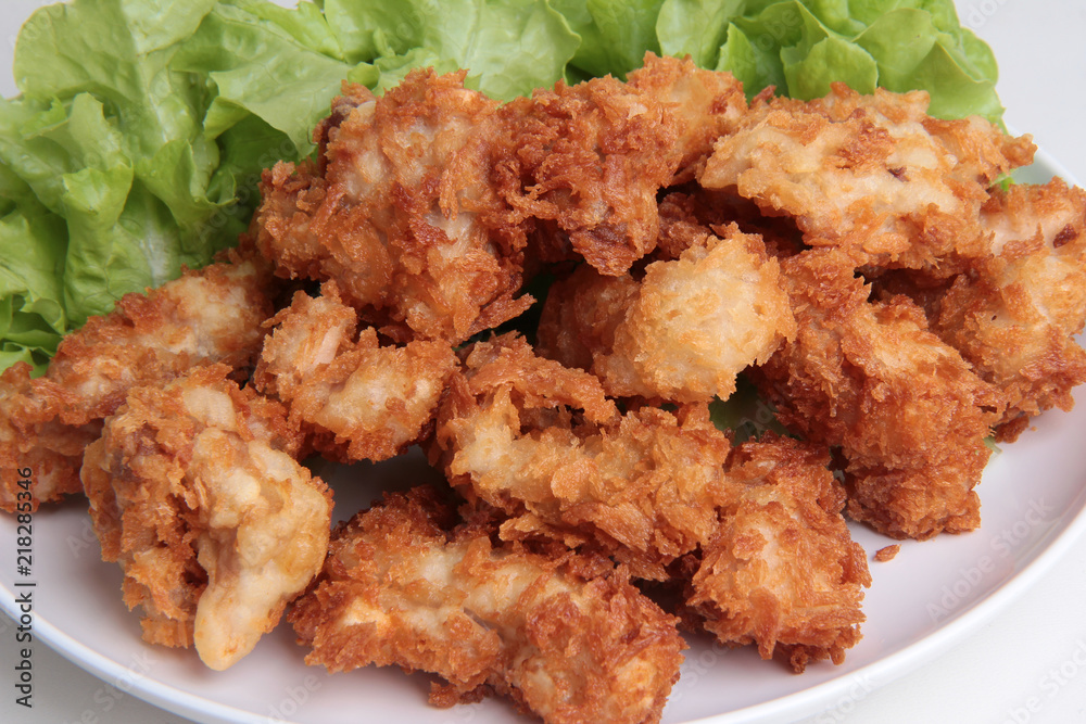 Crispy deep fried chicken served with green oak . Crispy deep fried chicken served with green oak .