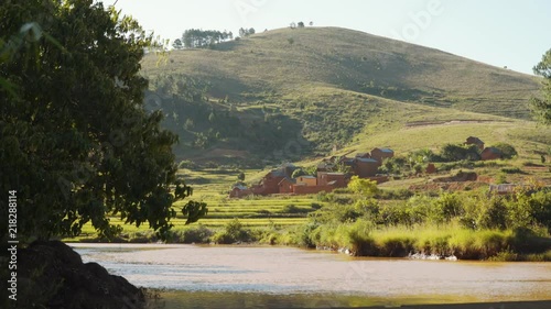 Landscape of Madagascar. River in the front, village and hills in the background. handheld photo