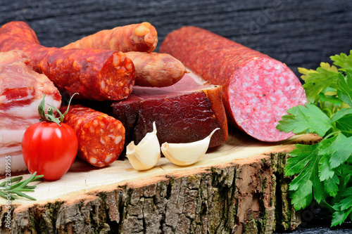 Sausages with bacon and salami on a wood cutting board