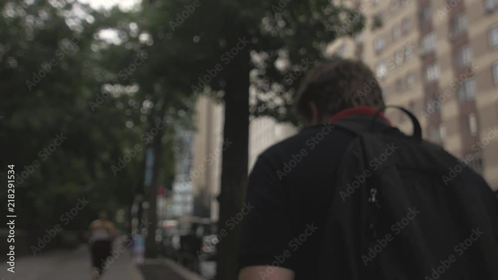 Teenager walking through a city with tall buildings. He is probably thinking and reflecting on his life and qustionning himself on his existence as he's looking around him. Teenager walking through a city with tall buildings. He is probably thinking and reflecting on his life and qustionning himself on his existence as he's looking around him.