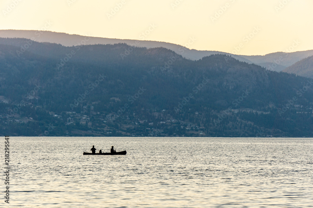 Okanagan Valley, Canada - August 05, 2018: People kayaking on a kayak in Okanagan lake BC Canada. Okanagan Valley, Canada - August 05, 2018: People kayaking on a kayak in Okanagan lake BC Canada.