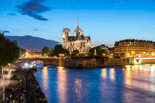Notre Dame de Paris with cruise ship on Seine river at night in Paris, France © ake1150