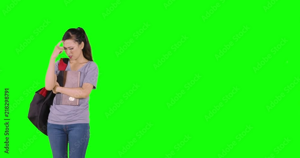 Confused female high school student walking back and forth while thinking in the studio. Shot in 4k resolution with green screen background Confused female high school student walking back and forth while thinking in the studio. Shot in 4k resolution with green screen background