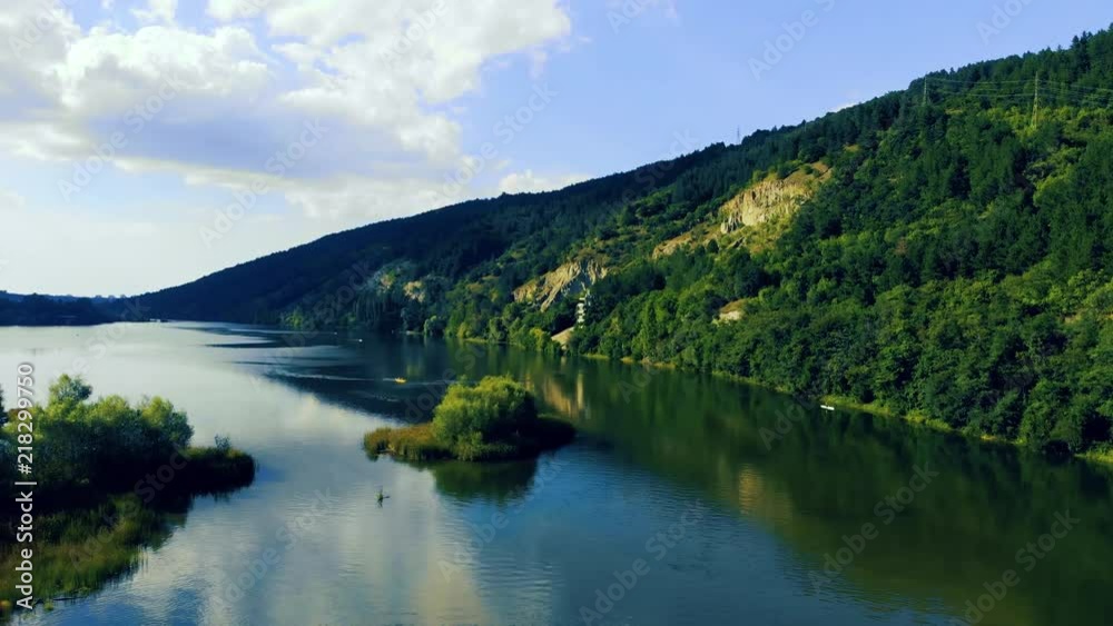 Ascending drone view of a lake Pancharevo with small island, canoes and clouds above. Ascending drone view of a lake Pancharevo with small island, canoes and clouds above.