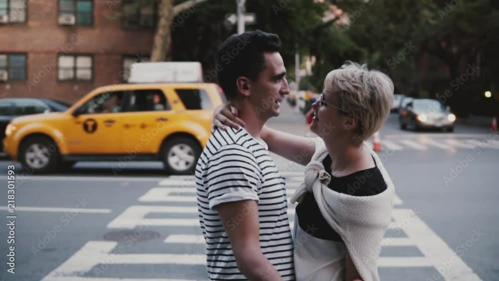 Slow motion happy young Hispanic man hugging and dancing with European girlfriend near New York busy street crossing. Slow motion happy young Hispanic man hugging and dancing with European girlfriend near New York busy street crossing.