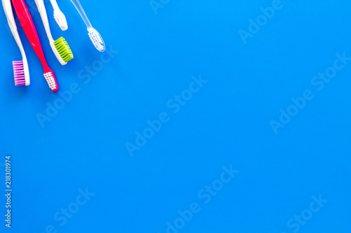 Clean teeth. Toothbrushes on blue background top view copy space