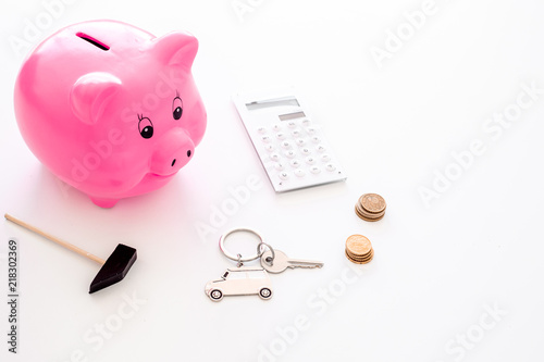 Money for buy car. Moneybox in shape of pig near keychain in shape of car, coins, calculator on white background copy space