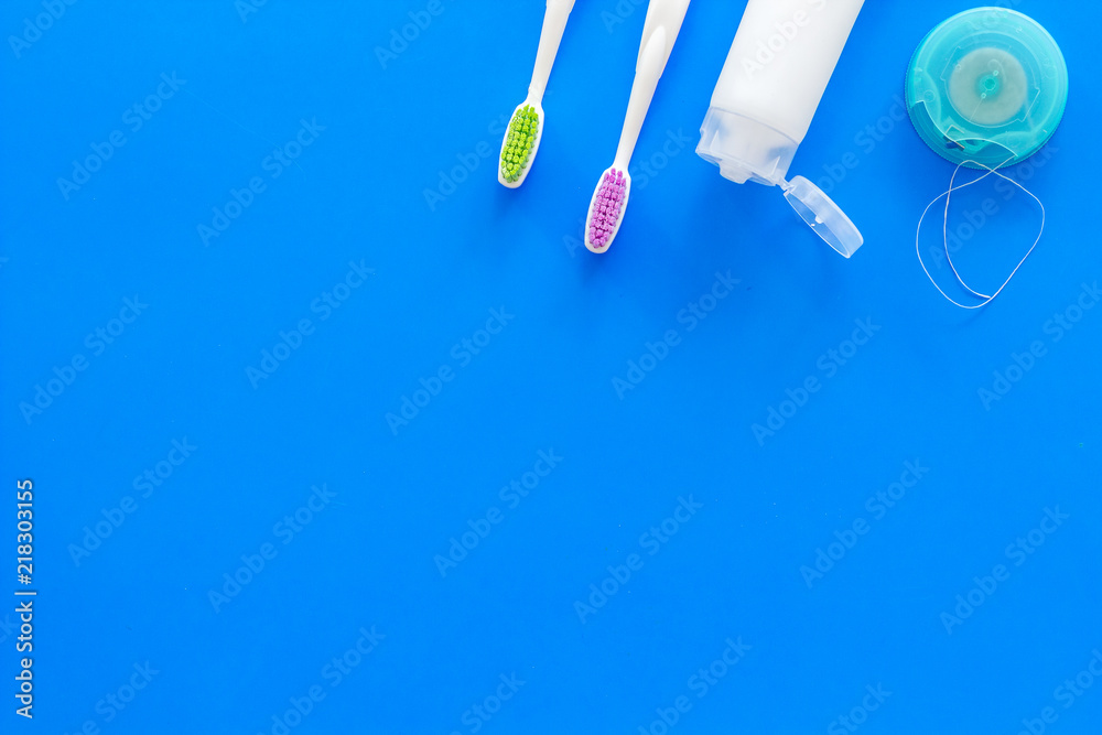 Set for daily teeth care. Toothbrush, tooth paste, dental floss on blue background top view copy space Set for daily teeth care. Toothbrush, tooth paste, dental floss on blue background top view copy space