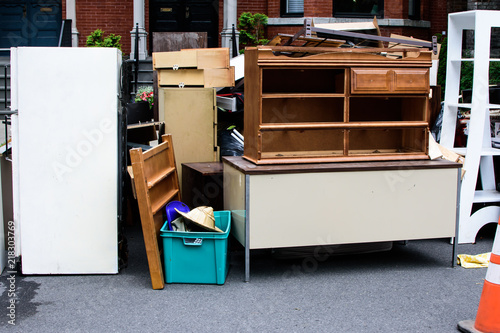 Items and old furniture on street outside house moving day or getting rid of junk concept