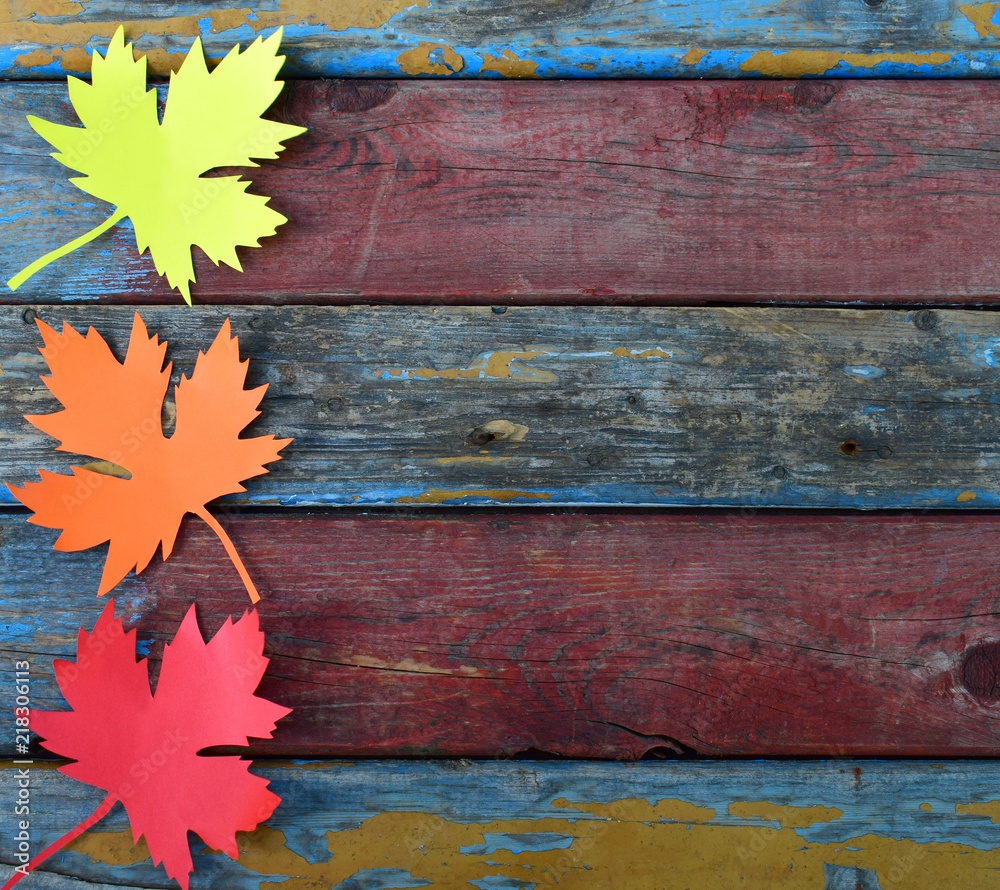 Fototapeta premium Yellow and red paper maple leaf on wooden background. Hello Autumn concept. Handmade crafts. Children's DIY. Copy space.