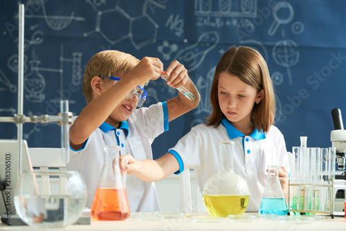 Kids working on scientific experiment in school laboratory
