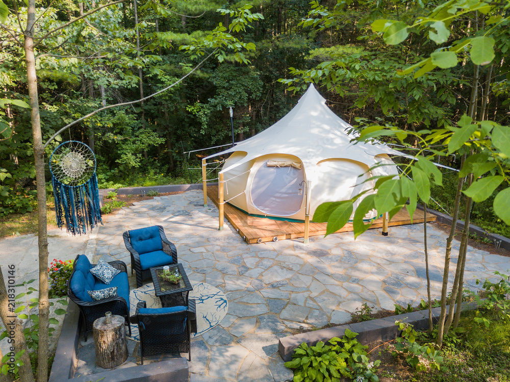 Aerial drone shot of a glamping tent in a forest
