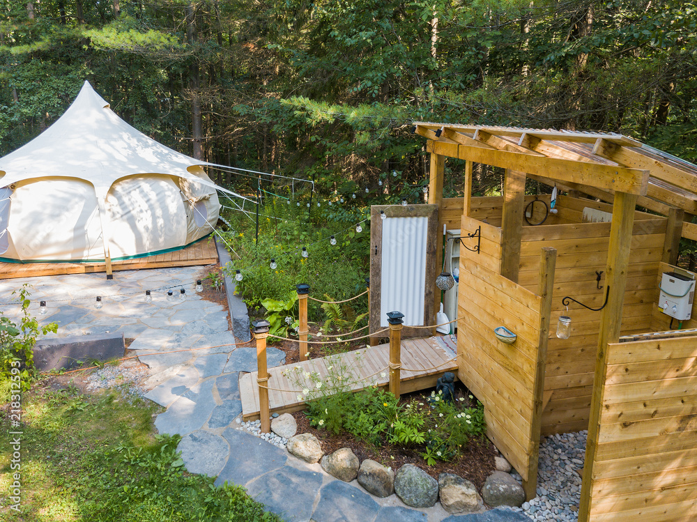 Aerial drone shot of a glamping tent in a forest