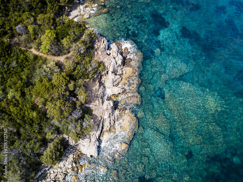 Aerial view of an amazing rocky and green coast bathed by a transparent and turquoise sea. Sardinia, Italy.