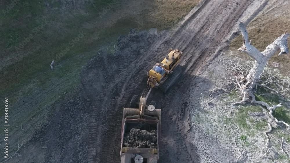 towed scraper hauling mud behind a bulldozer in the green hills towed scraper hauling mud behind a bulldozer in the green hills