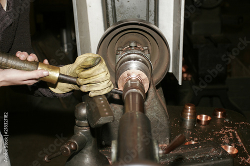 Worker working with hand on turn in a copper factory.