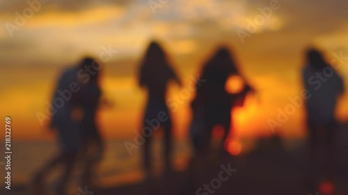 Group of people dancing during the sunset. Blurred slow motion.