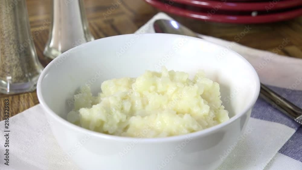 Spooning mashed cauliflower into a bowl, slow motion Spooning mashed cauliflower into a bowl, slow motion
