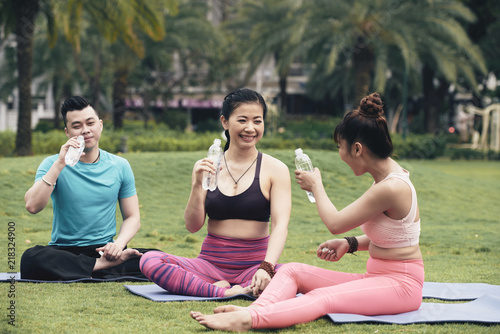 Vietnamese young people drinking fresh water during break between exercises
